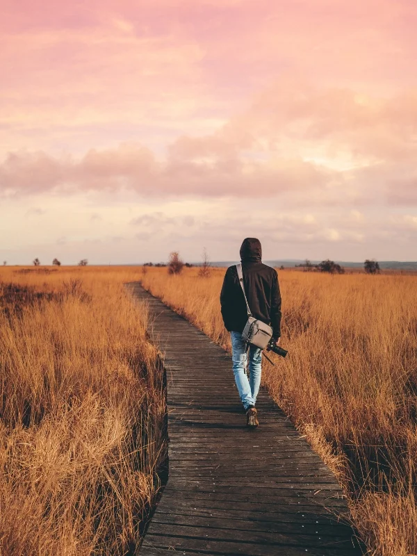 Persona caminando por un sendero, simbolizando el crecimiento de personas y organizaciones en el ecosistema empresarial.